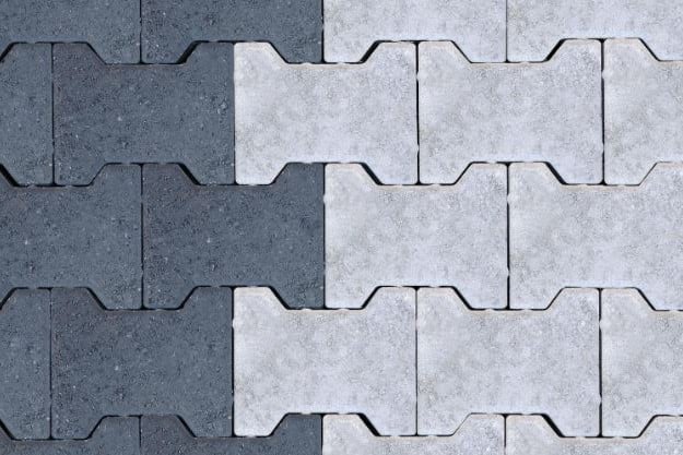 Adocreto vibrocomprimido gris y blanco, similar a piezas de rompecabezas