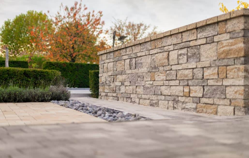 Fachada moderna con muro de block cara de piedra y jardín