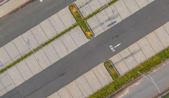 Aérea de estacionamiento con adocreto y adopasto, señal de salida.